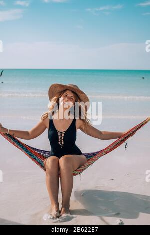 Eine Frau sitzt in einer Hängematte am Strand in Holbox, Mexiko Stockfoto