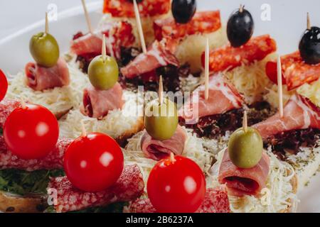 Köstliche Häppchen mit Salami, Schinken, Oliven, Käse und Gewürzen Stockfoto