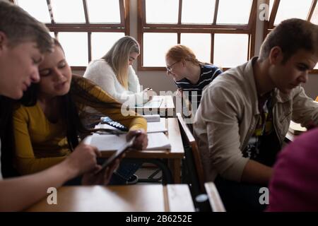 Seitenansicht der Kursteilnehmer, die in der Klasse sprechen Stockfoto
