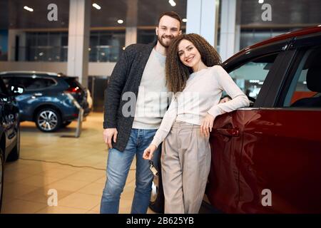 Fröhliches, ehrfürchtiges Paar hat sich für ein Auto entschieden, Nahaufnahme Foto.Familie ist bereit zu reisen. Nahaufnahme Foto Stockfoto
