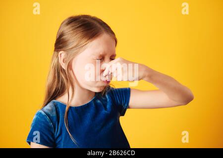 Little Redhead Girl Bedeckte Nase Für Schlechten Geruch Stockfoto