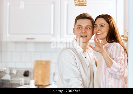 Junges fröhliches glückliches Paar standert im kikthen, Nahfoto. Kopierraum, Familie träumt von gelungenem erreichen Luxusleben. Aufgeregt junger Schein Stockfoto