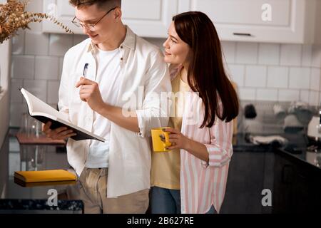 Junge Paare arbeiten als Freiberufler zu Hause, Nahaufnahme, Paar schreibt Zukunftspläne, Ziele, Ziele Stockfoto