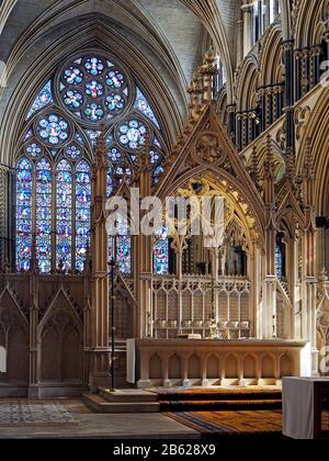 Im Inneren der Kathedrale von Lincoln - die atemberaubenden Bögen und Maßwerk des Chores mit Glasfenster über den geschnitzten Stein hinaus. Stockfoto