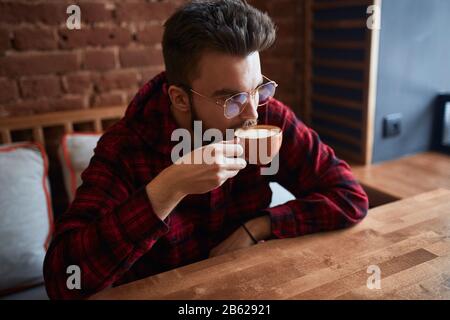 Junger, ernsthafter Mann, der Kaffee im Café trinkt. Nahaufnahme, Freizeit, Lifestyle.Quality Kaffee Stockfoto
