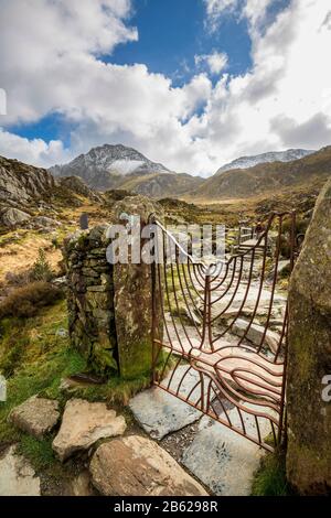 Das schmiedeeiserne Tor zum Weg nach Llyn Idwal mit dem Tryfan-Berg im Hintergrund, Snowdonia National Park, Nordwales Stockfoto