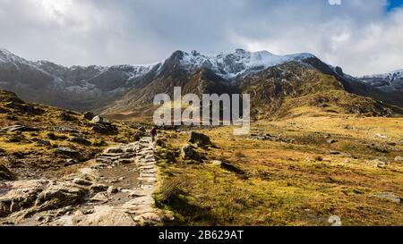 Der Steinweg, der zum Lake Idwal führt, und die schneebedeckten Berge von Snowdonia, Wales Stockfoto