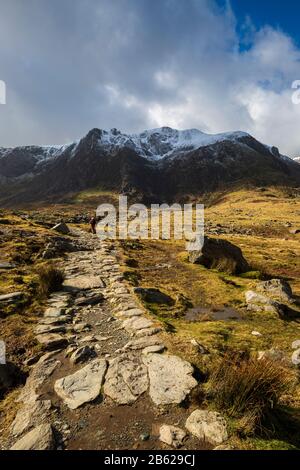 Der Steinweg, der zum Lake Idwal führt, und die schneebedeckten Berge von Snowdonia, Wales Stockfoto