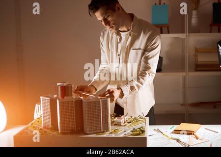 Junger blonder Kerl, der während der Arbeit in einem Modellbüro technische Werkzeuge verwendet, Nahansicht pho Stockfoto