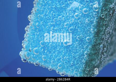 Makro für blauen Spülschwamm. Blasen, unter Wasser. Poröser Makroschwamm. Poröser blauer Hintergrund im Nahaufnahme. Stockfoto