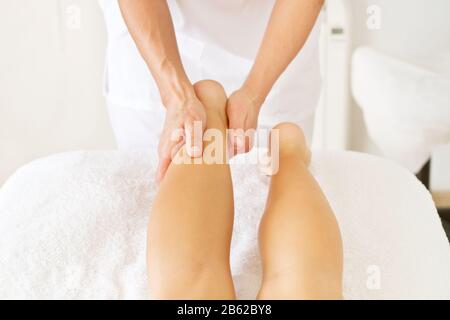 Massage und Physiotherapie an eine Frau in ihrem Fuß Stockfoto