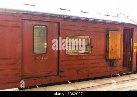 Leerer Bahnsteig eines Bahnhofs in Sri Lanka. Alte verrostende Zugwagen. Es sieht aus wie ein vergangener Ort, aber es ist nicht. Stockfoto