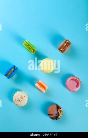 Verschiedene Arten von farbenfrohen süßen Makronen Desserts auf blauem Hintergrund Stockfoto