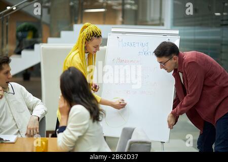 Junge Paare unterrichten die Geheimnisse des Marketings neuen Mitarbeitern, schließen Foto: Management, Frau schreibt Informationen über Marketing Stockfoto
