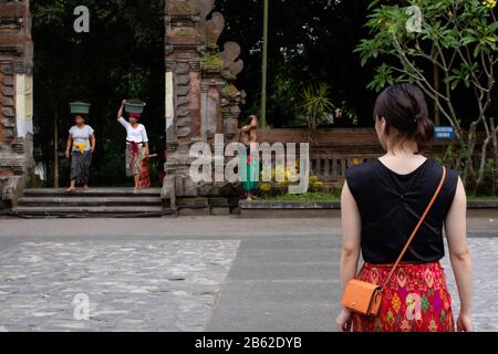 Bali, Indonesien - 24. 6 2019: Eine Frau, die im Urlaub in einen balinesischen Tempel geht Stockfoto