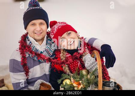 Junge Paare in warmen Pullovern im Winter blicken auf den Himmel. Stockfoto