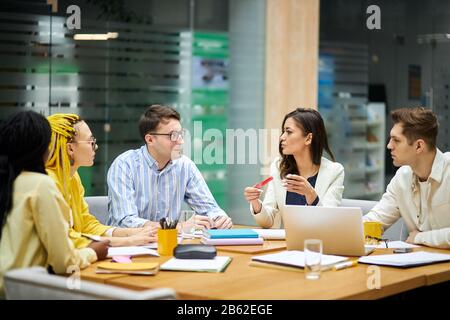 Portrait des fröhlichen, kreativen, ambitionierten Teams, das bei einem Meeting im Büro spricht. Nahaufnahme Foto, Entfall, Gespräch Stockfoto