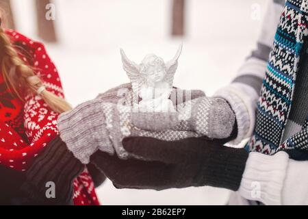Ein Paar in der Liebe hält in den Händen weißes Engelspielzeug. Stockfoto