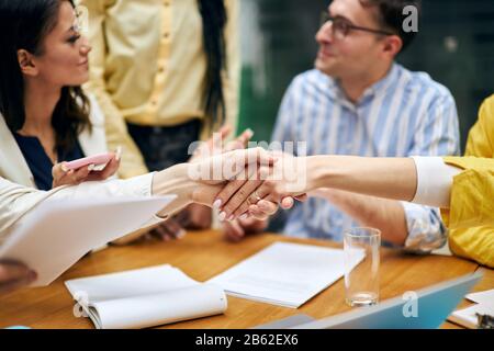 Junge Frauen begrüßen sich bei der Sitzung. Hallo. Guten Morgen, schön, Sie kennenzulernen, Nahaufnahme eines geschnittenen Fotos, Leute reden im verschwommenen Hintergrund Stockfoto