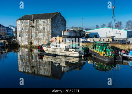 Eine alte Mühle und Wasserfahrzeuge an der Wakefield Wharf und Boatyard, auf der Calder & Hebble Navigation, Wakefield, West Yorkshire, Großbritannien Stockfoto