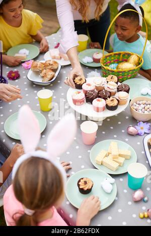 Mutter Mit Kindern, Die Hase Ohren Tragen Und Die Osterparty Im Freien Im Garten Zu Hause Genießen Stockfoto