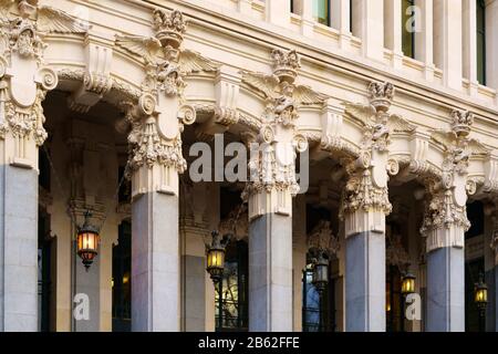 Architektur im Detail im Cybele-Palast im historischen Herzen von Madrid, Spanien. Säulen, Skulpturen und ornamental hängende Laternen im Rathaus. Stockfoto