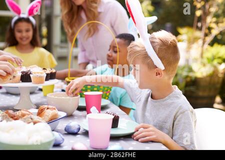 Mutter Mit Kindern, Die Hase Ohren Tragen Und Die Osterparty Im Freien Im Garten Zu Hause Genießen Stockfoto