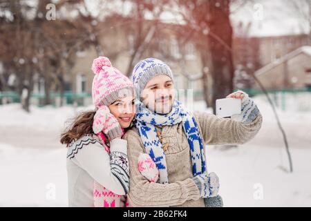 Ein Paar liebt es, selfie zum Winterpicknick im Park zu machen Stockfoto
