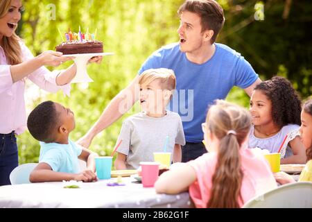 Eltern Und Sohn Feiern Geburtstag Mit Freunden, Die Party In Garden At Home Haben Stockfoto