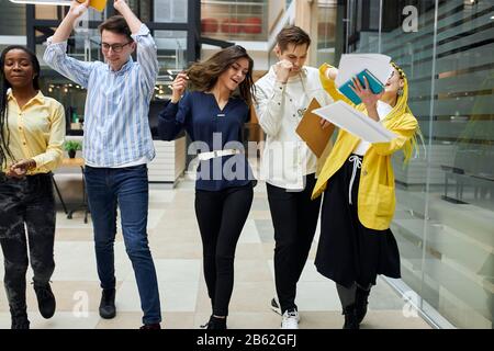 Gruppe fröhlicher Geschäftsleute, die auf der Straße spazieren, sich über erfolgreichen Vertrag, Erfolg, Glück, positives Gefühl und Emotionen freuen Stockfoto