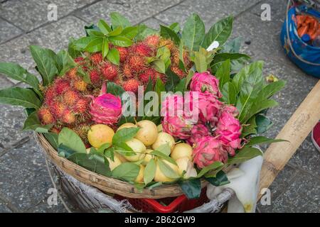 Bunte exotische Obstkorb, mit Drachenfrüchten, Rambutan und Birnen, auf dem Markt von Dali, Yunnan, China verkauft Stockfoto