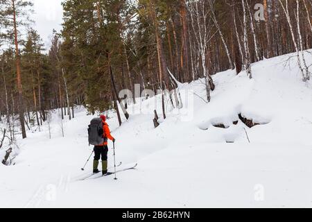 Junger Tourist, der im Winter auf einem Skihügel im Freien steht Stockfoto