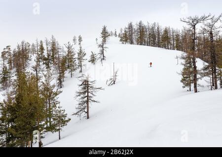 Winterlandschaft mit einsamen Skifahrern auf dem Berg Stockfoto