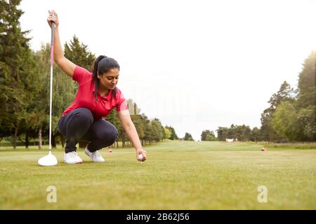 Weiblicher Golfspieler, Der Sich Vorbereitet, T-Stück Zu Schlagen, Schoß Entlang Fairway Mit Fahrer Stockfoto