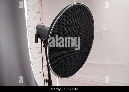 Beauty Dish Studio Blitz mit Gitterkamm, der auf einem Blitzgerät in einer Beleuchtungswerkstatt montiert ist, eingeschaltet Modeleuchte Stockfoto