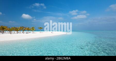 Idyllischer Strand auf den Malediven auf der Insel Meeru mit Palmen, Bewölktem Himmel und indischem Ozean. Stockfoto