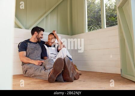 Ein Paar, Das Eine Pause Vom Gebäude Outdoor Summerhouse In Garden nimmt Stockfoto