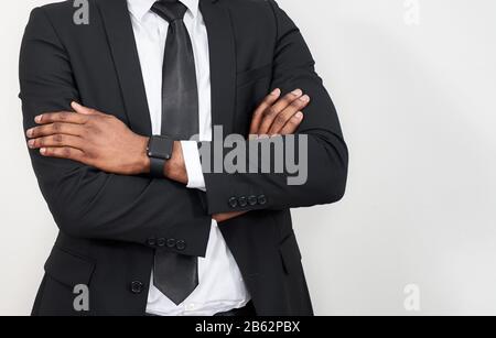 Zugeschnittenes Porträt eines erfolgreichen afrikaners mit Armen über grauem Hintergrund mit Kopierbereich Stockfoto