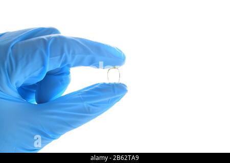 Hand hält eine Fischölpille. Tragen von blauem medizinischem Nitrilhandschuh. Stockfoto