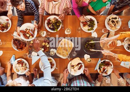 Overhead-Aufnahme Der Multi-Generation-Familie, Die Am Tisch Sitzt Und Zusammen Zu Hause Essen Genießt Stockfoto