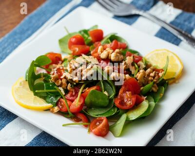 Wintersalat mit Tomaten und gerösteten Walnüssen. Stockfoto