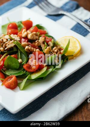 Wintersalat mit Tomaten und gerösteten Walnüssen. Stockfoto