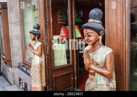 Eingang zu einem farbenfrohen Thai-Souvenirladen und Massagesalon mit Statuen asiatischer Frauen in nationalen Kostümen Stockfoto