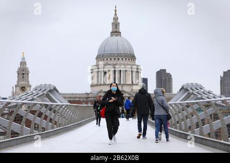 London, Großbritannien. März 2020. Eine Person, die eine Maske trägt, läuft am 9. März 2020 über die Millennium Bridge in London, Großbritannien. Ab 9 Uhr (00 Uhr GMT) am Montag haben 319 Menschen in Großbritannien positiv auf das neuartige Coronavirus getestet, nach Angaben des Gesundheitsministeriums und der Sozialfürsorge von 273 am selben Punkt am Sonntag. Kredit: Tim Ireland/Xinhua/Alamy Live News Credit: Xinhua/Alamy Live News Stockfoto