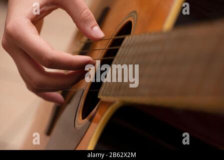 Teenagermädchen, die die Gitarre aus nächster Nähe spielen. Stockfoto