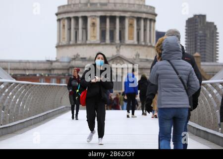 London, Großbritannien. März 2020. Eine Person, die eine Maske trägt, läuft am 9. März 2020 über die Millennium Bridge in London, Großbritannien. Ab 9 Uhr (00 Uhr GMT) am Montag haben 319 Menschen in Großbritannien positiv auf das neuartige Coronavirus getestet, nach Angaben des Gesundheitsministeriums und der Sozialfürsorge von 273 am selben Punkt am Sonntag. Kredit: Tim Ireland/Xinhua/Alamy Live News Credit: Xinhua/Alamy Live News Stockfoto