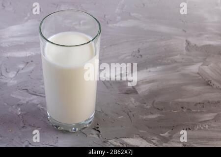 Kefir in einer Glasflasche auf grauem Hintergrund. Milchkost für Gewichtsverlust. Stockfoto