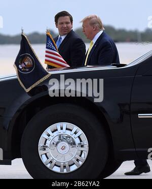 US-Präsident Donald Trump trifft auf den Gouverneur von Florida Ron DeSantis, als er auf einem Luftwaffenplatz Am Orlando Sanford International Airport in Sanford ankommt. Trump soll an einer privaten Spendenaktion in der Gegend teilnehmen. Stockfoto