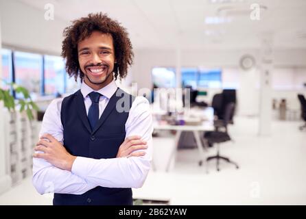 Porträt Eines Selbstbewussten Jungen Geschäftsmannes, Der Anzug Trägt, Der In Modernen Büros Steht Stockfoto