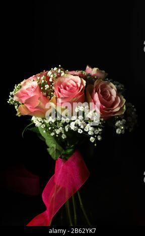 Blumenstrauß aus rosa Rosen isoliert auf dunklem Hintergrund. Nahaufnahme. Stockfoto